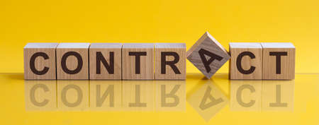CONTRACT - word from wooden blocks with letters, sorry concept, yellow background.の写真素材