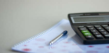 The calculator and the financial report. A workplace of the businessman.