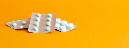 Pills, tablets and bottle on turquoise background. Copy space.の写真素材