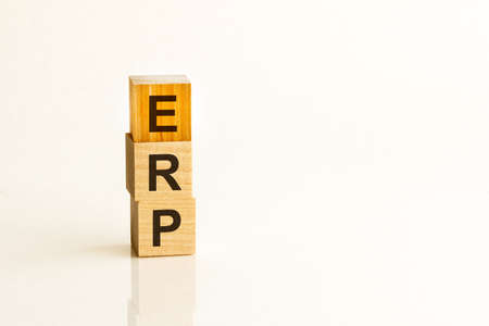 Pile with three wooden cubes - letters ERP meaning Enterprise Resources Planning on them, space for more text - images at right side.の写真素材
