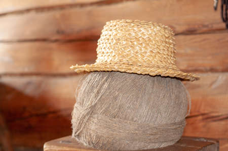 An old straw hat hangs on a ball of gray linen thread. Electoral focus Straw Hat hanging in the green garden. Selective focusの写真素材