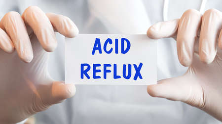 Doctor holding a card with text ACID REFLUXの写真素材