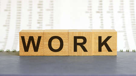work word made with building blocks. work on wooden cubes on gray notepad. Business concept.