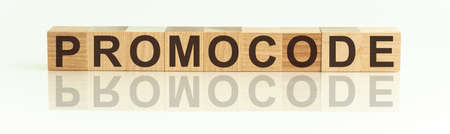Wooden Blocks with the text: PROMOCODE. The text is written in black letters and is reflected in the mirror surface of the table. New business relaunch startup conceptの写真素材