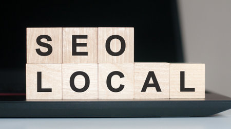 Text SEO LOCAL written on wooden block on computer keyboard against black backgroundの写真素材
