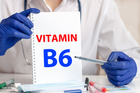 Doctor holding a white card in hands and pointing the word VITAMIN B6. Healthcare conceptual for hospital, clinic and medical busines.の写真素材