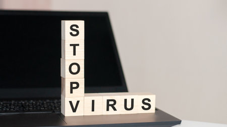 Stop Virus - text written on wooden block on computer keyboard against black background. conceptの写真素材