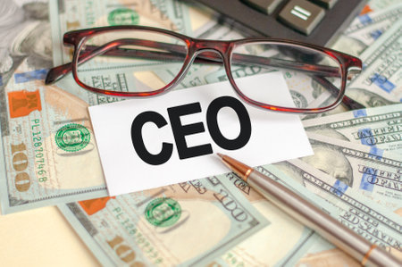 Finance and economics concept. On the table are bills, a bundle of dollars and a sign on which it is written - CEO. CEO - Chief Executive Officerの写真素材