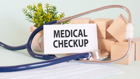 Card with words MEDICAL CHECKUP, stetoscop, wooden blocks and flower on table, medical and healthcare conceptの写真素材