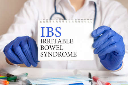 Doctor holding a tablet with text: IBS. IBS - Irritable Bowel Syndrome, medical concept.の写真素材