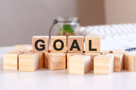 Goal concept with wooden blocks and coins on table, business conceptの写真素材