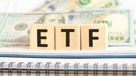 ETF - exchange-traded fund. Business concept on wooden cubes and dollars backgroundの写真素材
