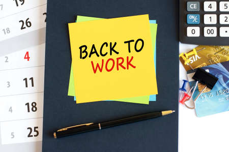 back to work - text on yellow paper on blue background, concept