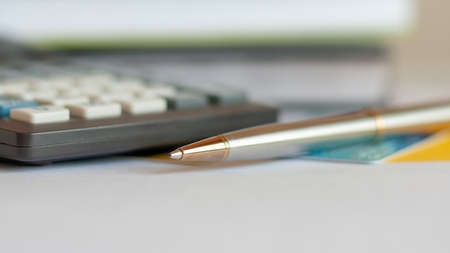 Close-up of silver pen and calculator on paper, business concept, selective focusの写真素材
