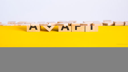 adapt word is made of wooden building blocks lying on the yellow table, conceptの写真素材