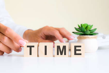 wooden blocks with letters time on the office desk, information and communication background, selective focus on office workplaceの写真素材