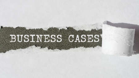 business cases. words. text on gray paper on torn paper background.