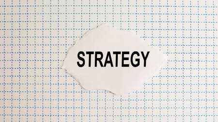 strategy text on a sheet of paper against the background of a checkered notebook page, conceptの写真素材