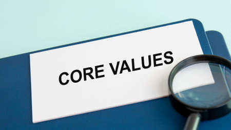 CORE VALUES word on white paper card and magnifying lens