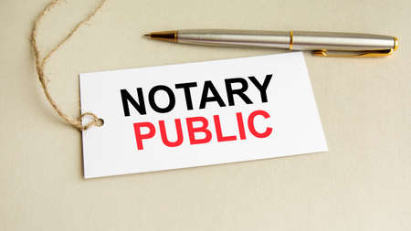 white card with text Notary Public with metal pen on gray backgroundの写真素材