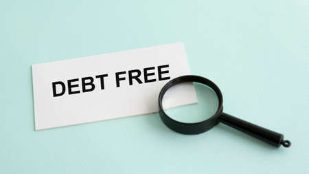 debt free word on white paper card and magnifying lensの写真素材