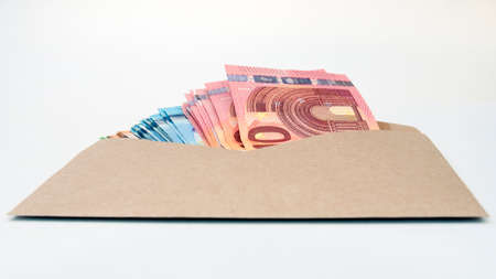 euro banknotes in broun envelope. open envelope with money banknotes on table. envelope with Euro money bills. closeup on envelope full of euro cash. international currency monetaryの写真素材