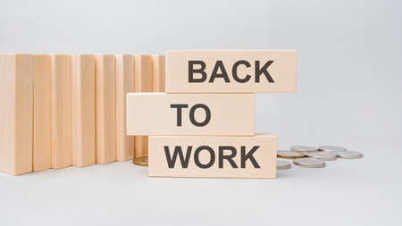 the words BACK TO WORK are written on a wooden cubes structure. Cube on a gray background. Can be used for financial, business concept. Selective focus. copy spaceの写真素材