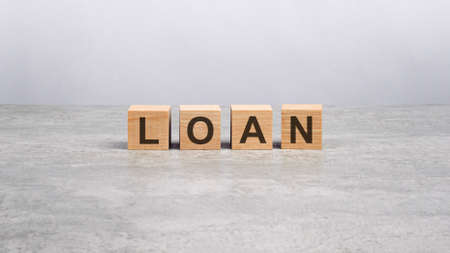 four wooden blocks with the letters LOAN on the bright gray table. business conceptの写真素材