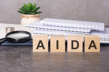 wooden blocks with text AIDA on black tableの写真素材