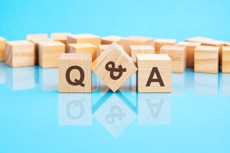 the text q and a written on the wooden cubes in black letters, the cubes are located on a bright...