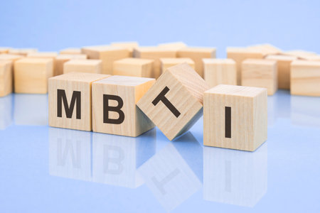 four wooden blocks with the letters MBTI on the bright surface of a pale lilac table. the inscription on the cubes is reflected from the surface. MBTI - short for Myers-Briggs Type Indicatorの写真素材