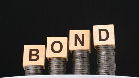 on a black background are coins and wooden cubes with the inscription - bond, business and economy concept.の写真素材