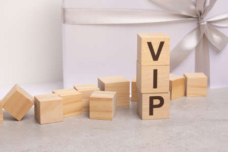 vip - letters on wooden cubes. concept on white gift box backgroundの写真素材