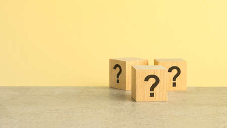 Cube with question mark on wooden background. Space for textの写真素材