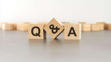 Q and A - an abbreviation of wooden blocks with letters on a gray background. selective focus.