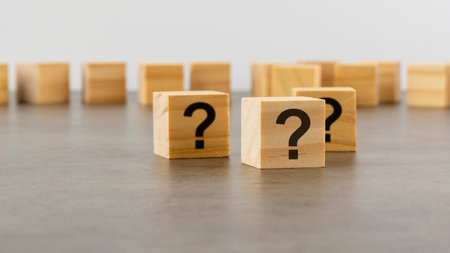 three wooden blocks with question marks on wooden table, closeup. space for text. wood backgroundの写真素材