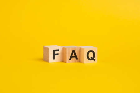 Wooden blocks with text FAQ on yellow paper. frequently asked question conceptの写真素材