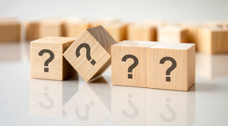 question mark shown on four wooden cubes on a gray background, business conceptの写真素材