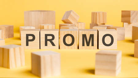 the word promo written on wooden cubes on yellow background. asset management or financial...