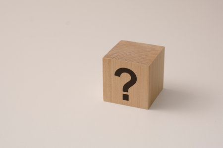 natural wooden cube with question mark on white backgroundの写真素材
