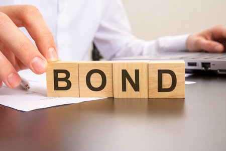 man made word bond with wood blocks on the background of the office table. selective focus.の写真素材