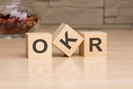 OKR - acronym from wooden blocks with letters, top view on grey backgroundの写真素材