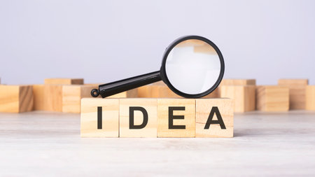 magnifying glass and wooden blocks with the text: IDEA. can be used for business, marketing and...