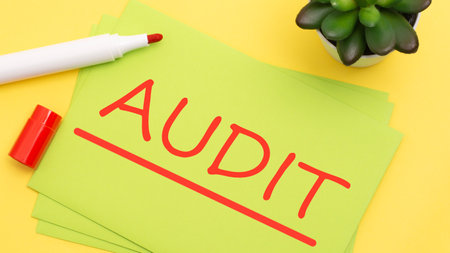 green paper with text Audit on a yellow background with red markerの写真素材