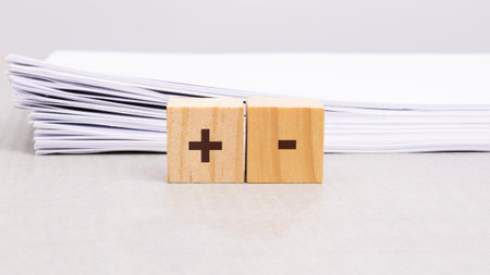 text plus and minus on wooden cube block. business concept. selection of persons to participate in...