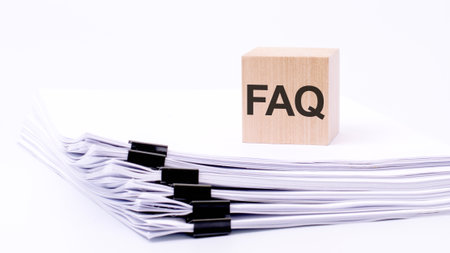 natural wooden cube or dice with letters FAQ - Frequency Asked Questions - on stack white paperの写真素材