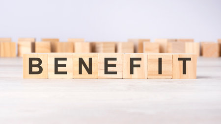word BENEFIT inscribed on wooden cubes lying on a light table. business concept.の写真素材