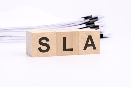 SLA letters on wooden cubes. the background is a white business papers. finance conceptの写真素材