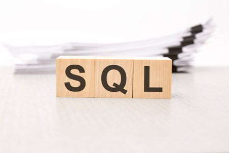 SQL letters on wooden cubes. the background is a white business papers. finance conceptの写真素材