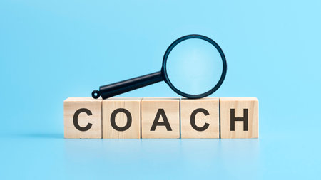 wooden cubes with the text: coach and magnifying glass, blue background. business conceptの写真素材